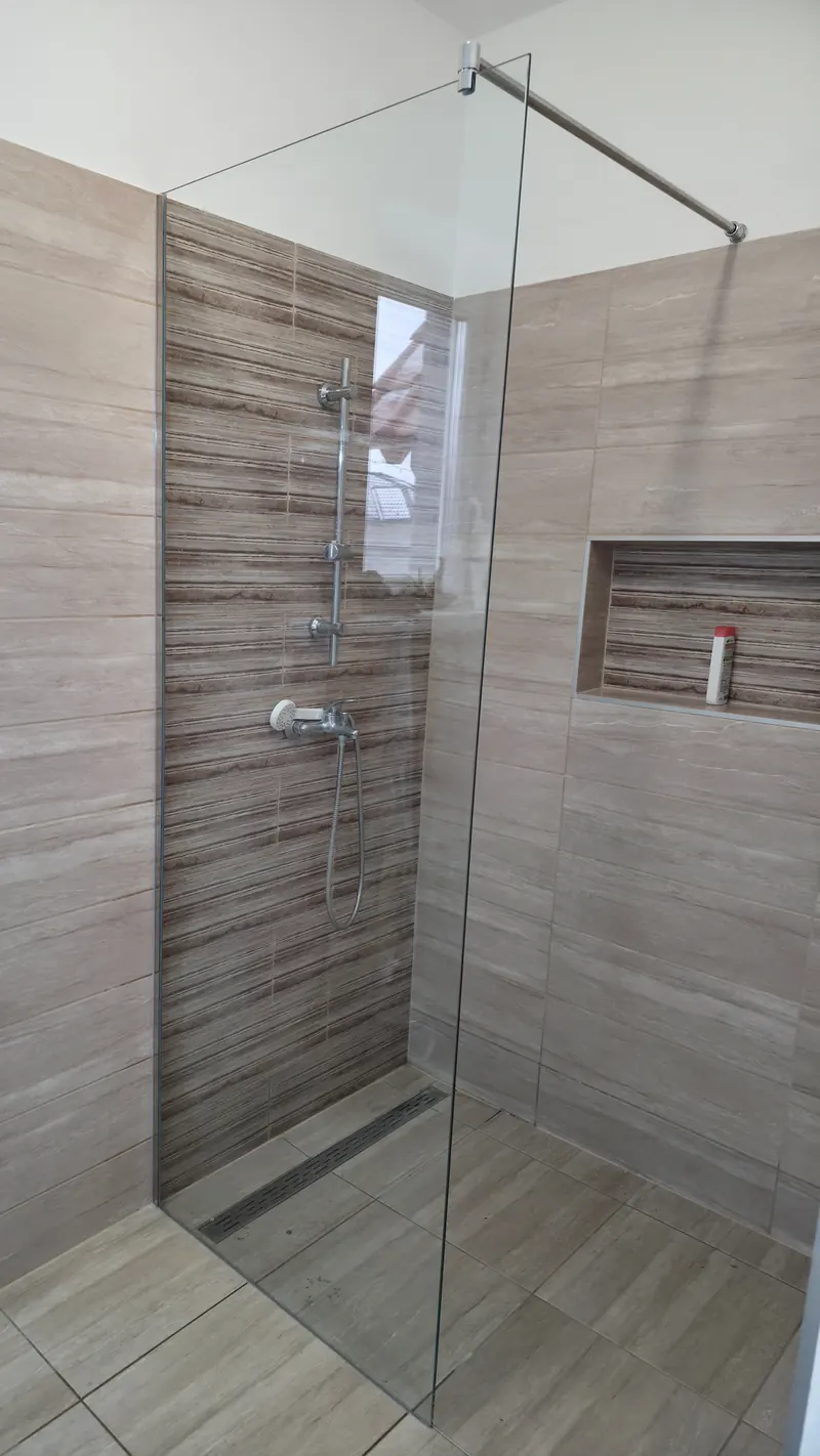 Magas, fix, víztiszta walk-in zuhanyfal burkolt zuhanyzóban